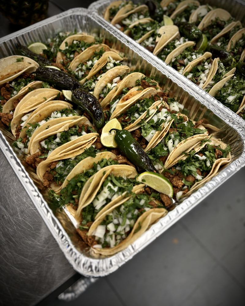 Trays of street tacos with cilantro and lime