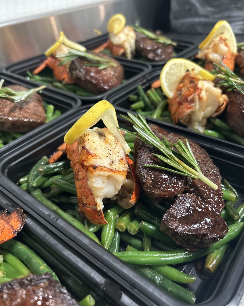 Plated steak and lobster tail meals with green beans